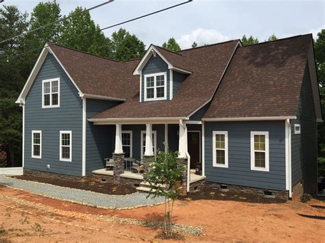 brown house with blue metal roof|brown house white trim.